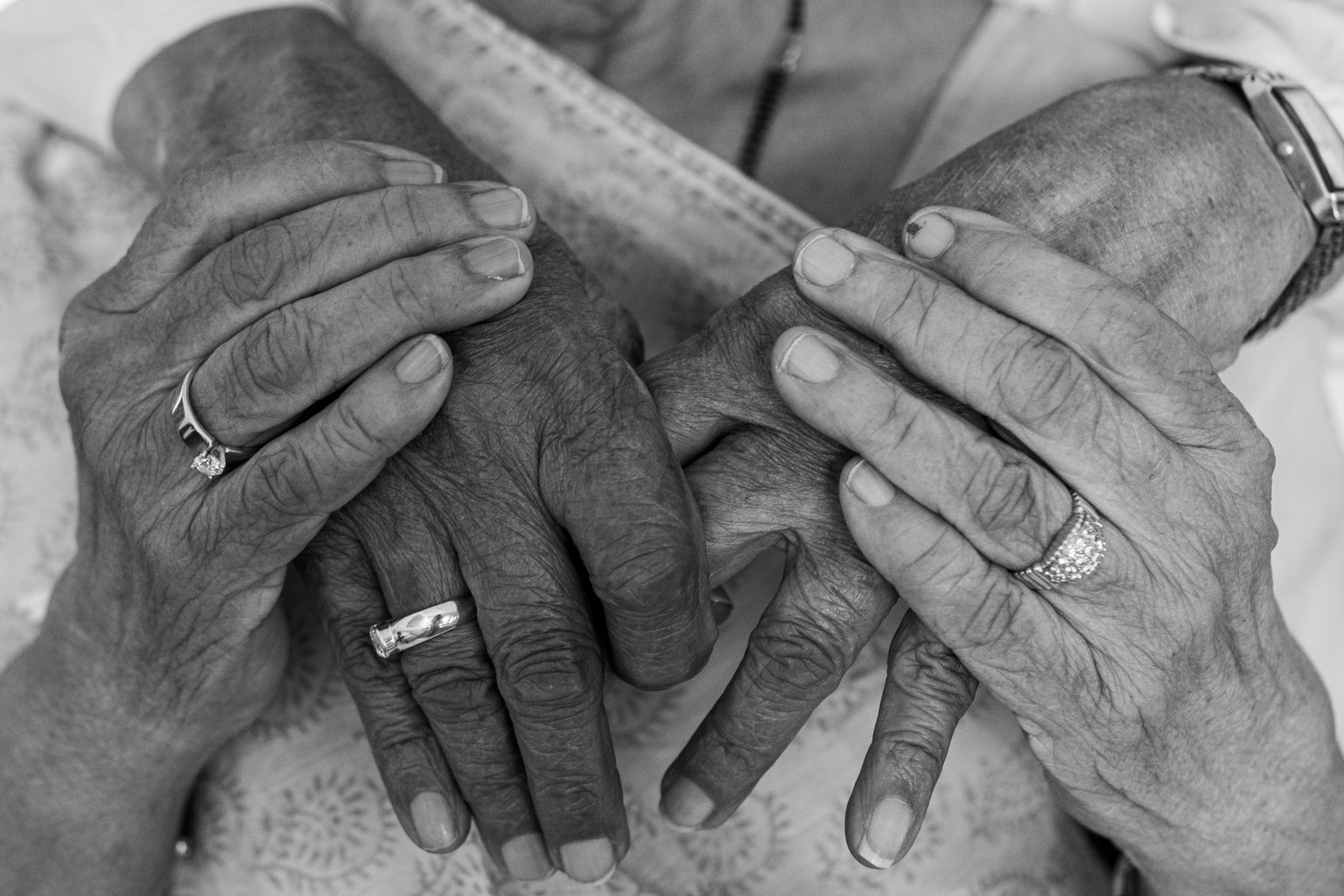 grayscale photo of old couple holding hands