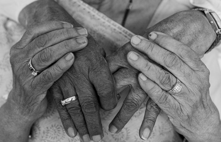 grayscale photo of old couple holding hands