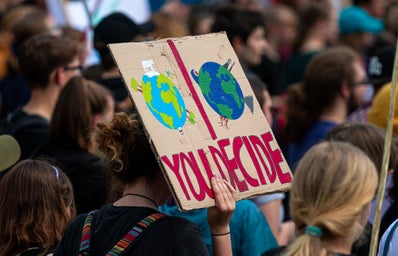 demonstration for climate change action - sign that says \"You decide\" with one clean earth and one dirty earth