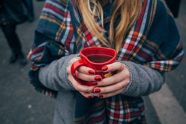 Red nails, woman holding tea, plaid scarf