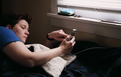 Person looking at their phone while in their bed – Shane
