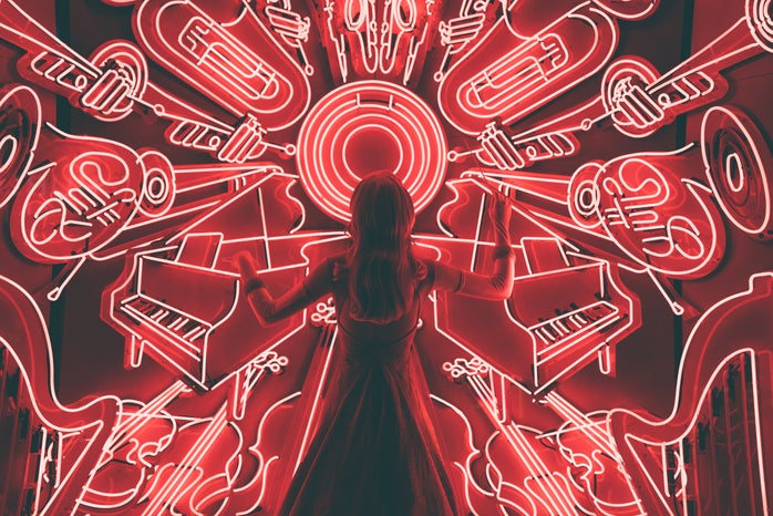 woman standing in front of neon music wall