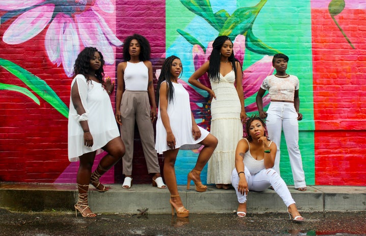 powerful women standing in front of a mural in white with friends