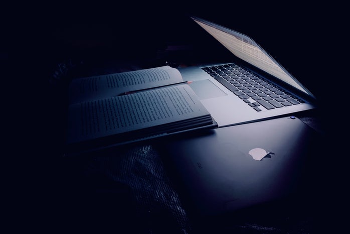 Half closed laptop over book