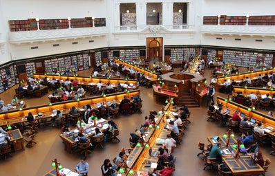 people studying and working side by side in large library