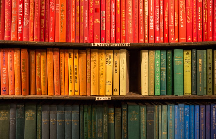 rainbow colored books on a shelf