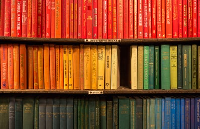 rainbow colored books on a shelf