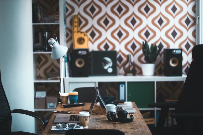 gray laptop computer near black acoustic earmuffs on brown wooden table