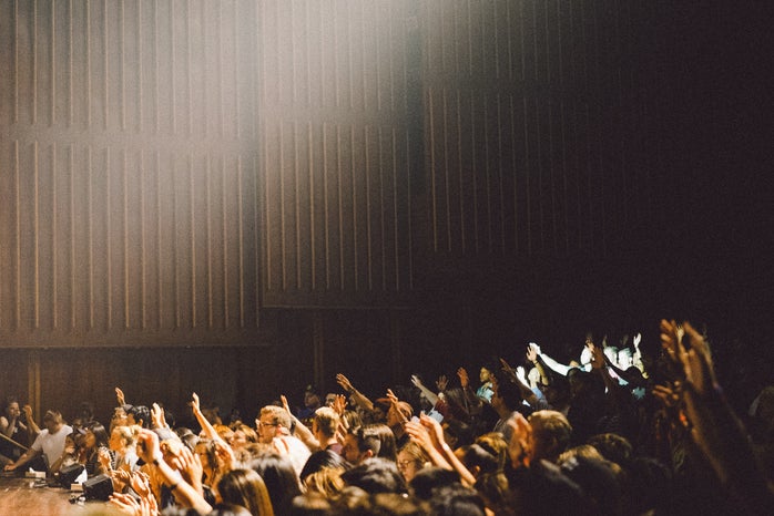 crowd of people raising their hands