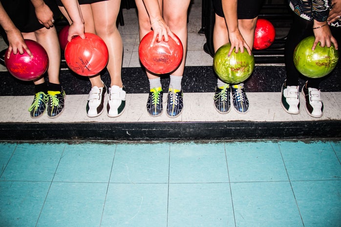 person holding bowling balls