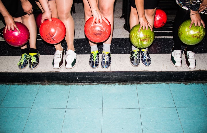 person holding bowling balls