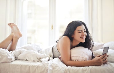 happy young woman browsing phone on bed 3807763?width=398&height=256&fit=crop&auto=webp