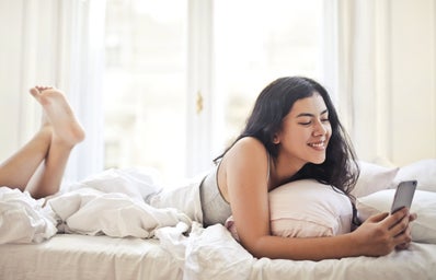 happy young woman browsing phone on bed 3807763?width=398&height=256&fit=crop&auto=webp
