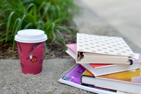red and white cup beside book