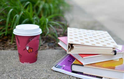 red and white cup beside book