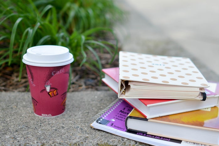 red and white cup beside book