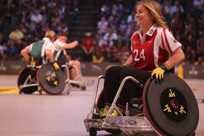 focus photo of woman in red and white polo shirt with black pants in ice wheelchair