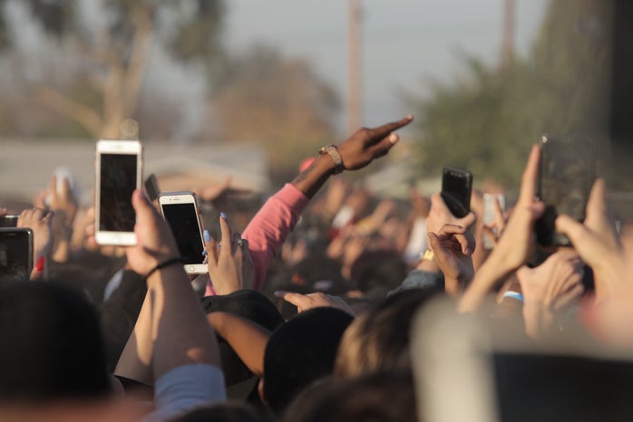 people holding smartphones in a crowd