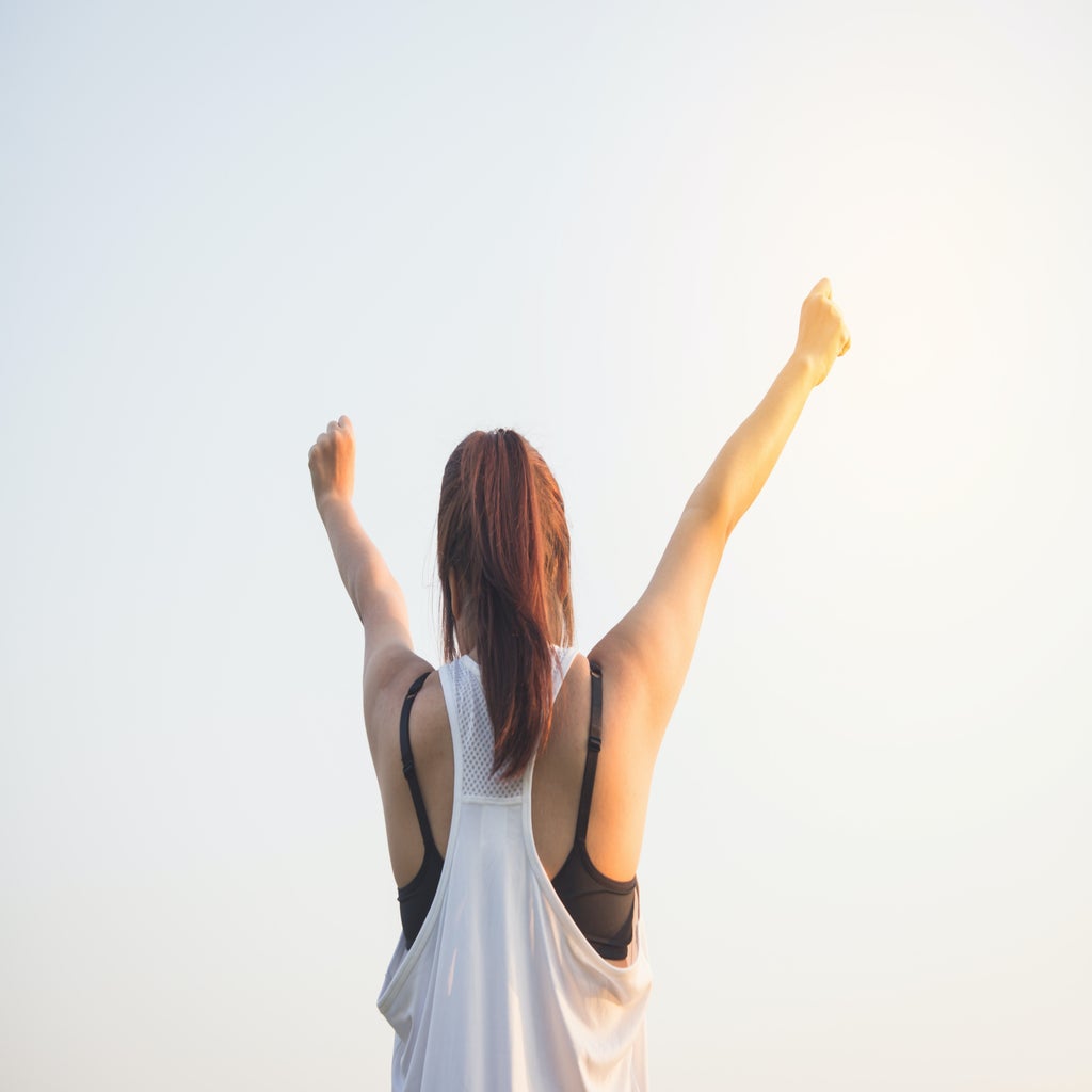 woman raising her hands in victory