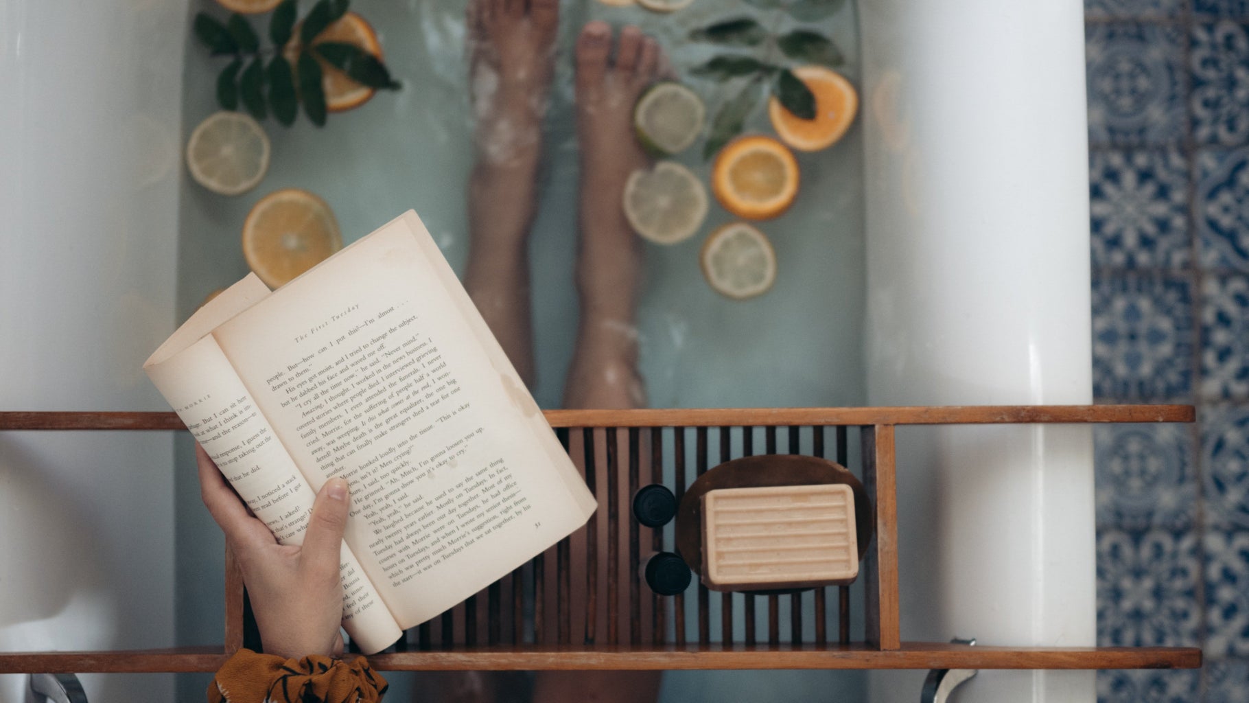 person holding book in a bath