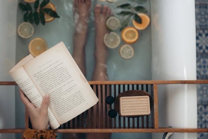 person holding book in a bath