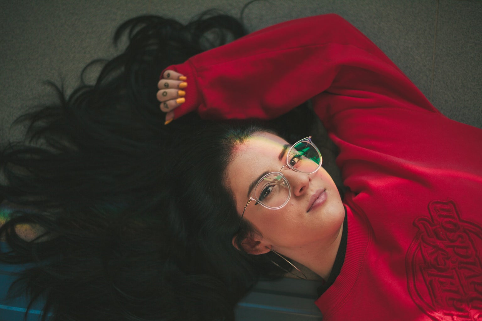 woman in red crew neck sweatshirt laying down on the ground?width=1024&height=1024&fit=cover&auto=webp