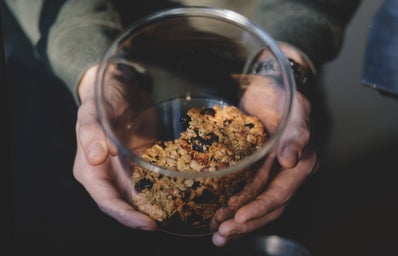person holding a clear jar of granola