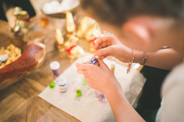 Close up of girl hands coloring eggs for easter