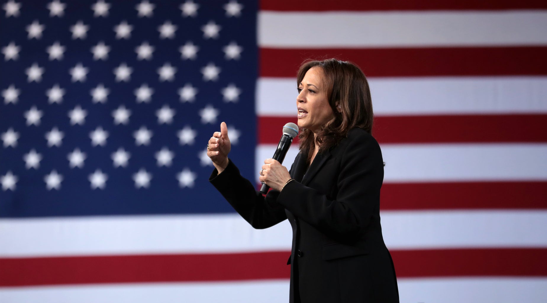 Kamala Harris speaking at an event in front of an American flag