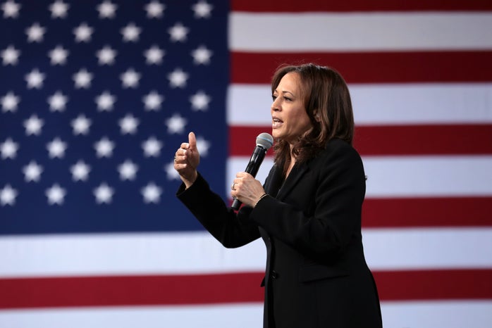 Kamala Harris speaking at an event in front of an American flag