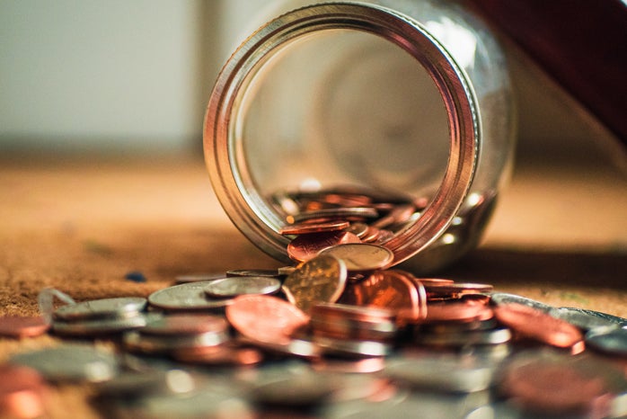 Pile of US coins spilling out of glass jar