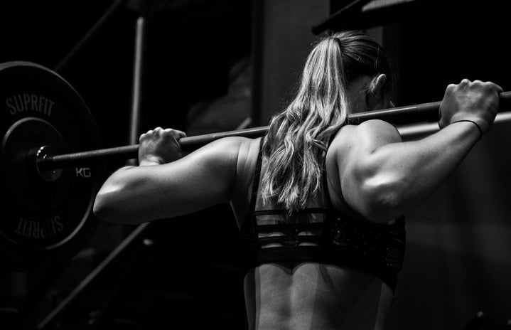 black and white photo woman lifting barbell