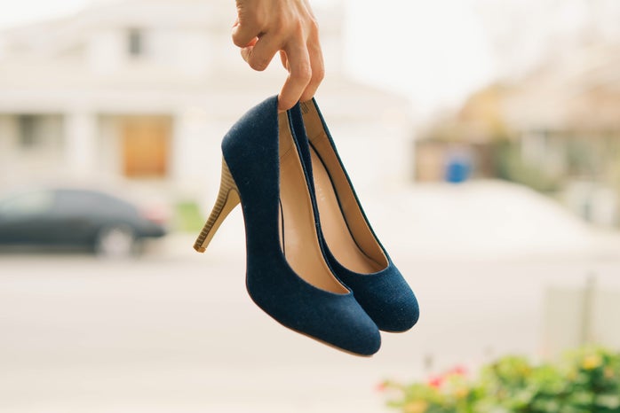 low-depth of field photo of person holding navy stilletos
