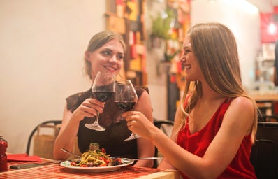 women drinking wine at dinner