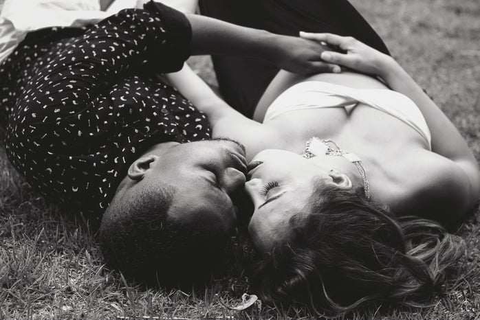 A couple sleeping next to each other outside.