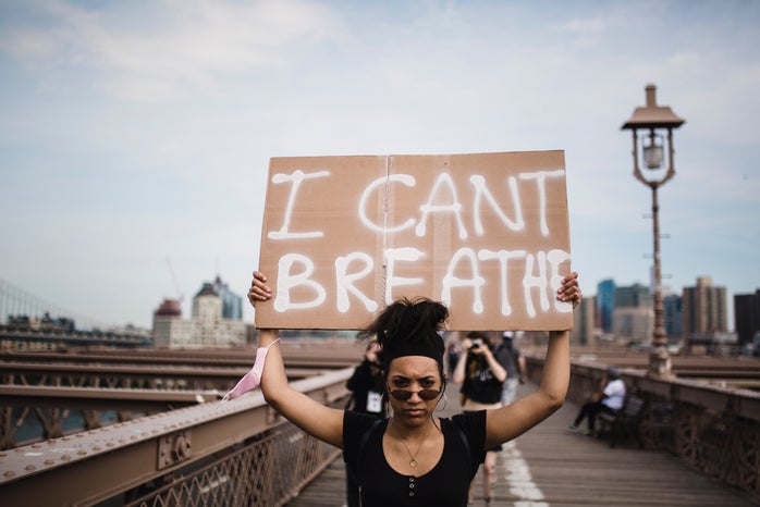 woman holding a sign that says "I can't breathe"