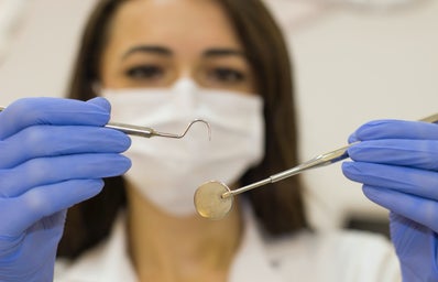 A dentist holding their tools