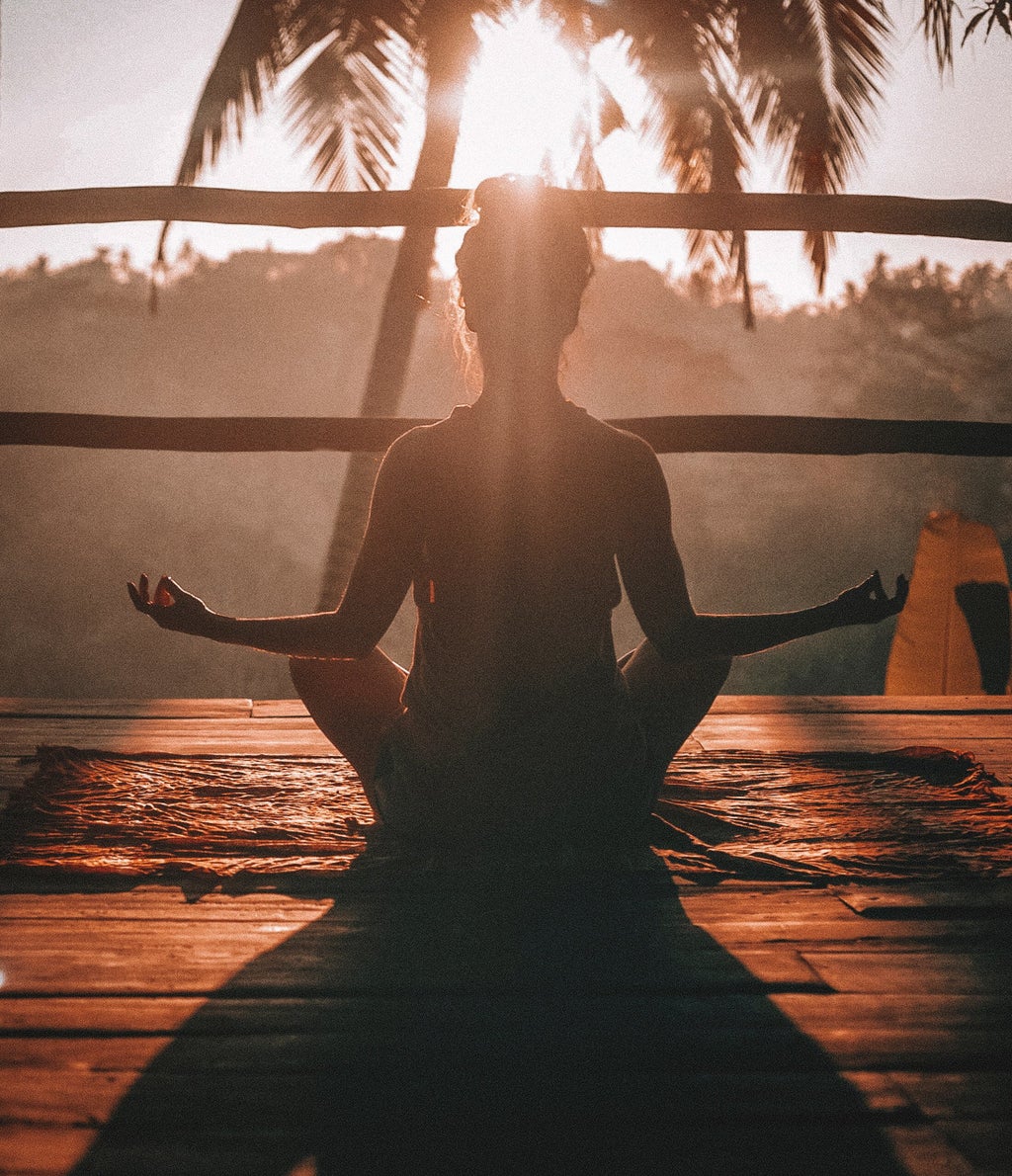 Woman doing yoga meditation on brown parquet flooring