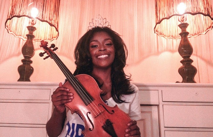 The new Miss Hampton holds up her violin