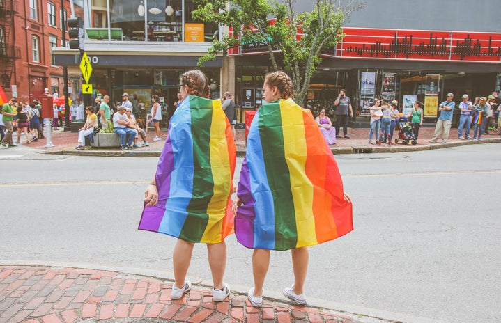 Two people wearing LGBTQ pride flags by Mercedes Mehling?width=719&height=464&fit=crop&auto=webp
