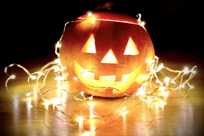 happy pumpkin wrapped in fairy lights