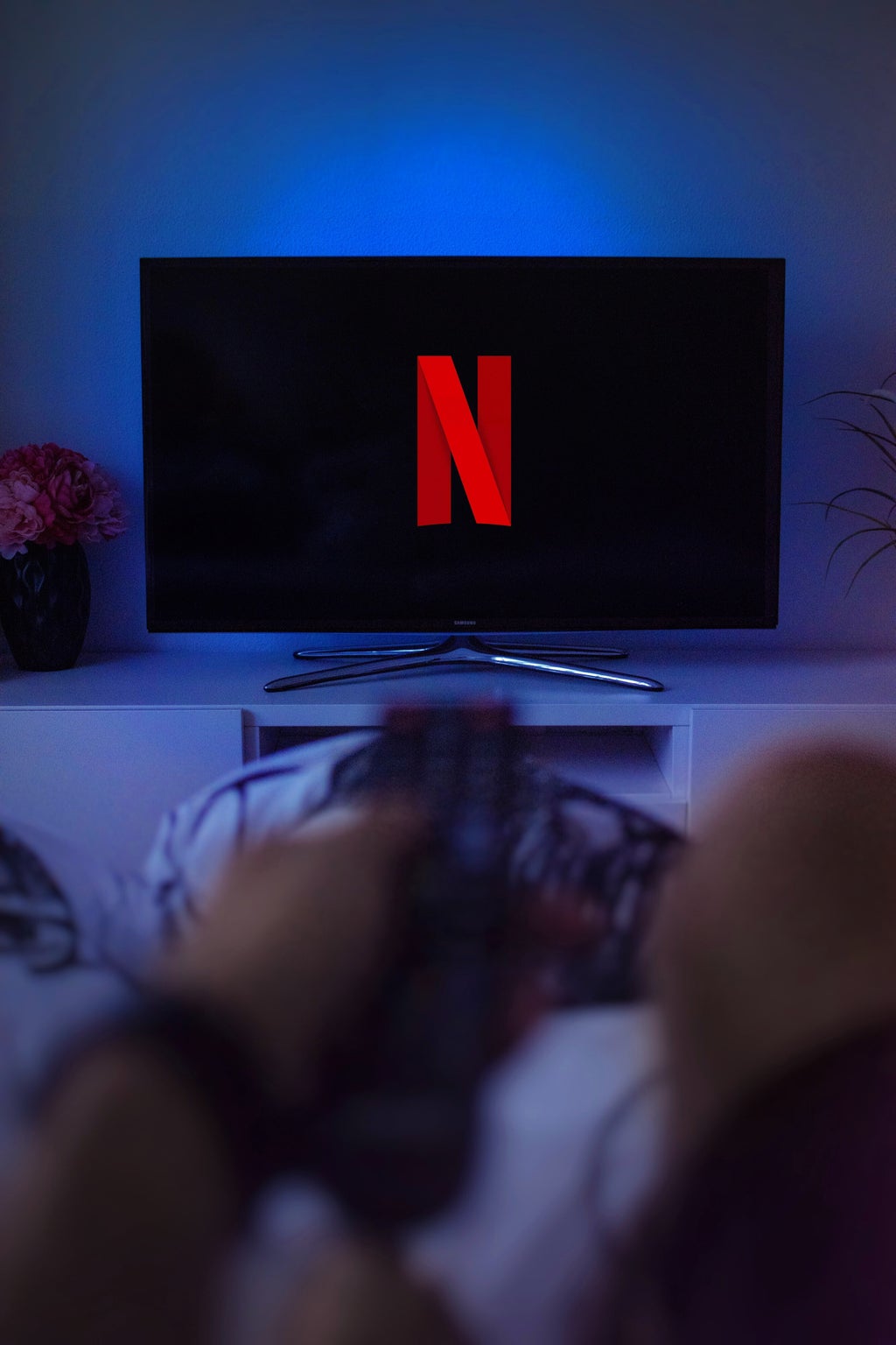 black flat screen tv turned on displaying netflix