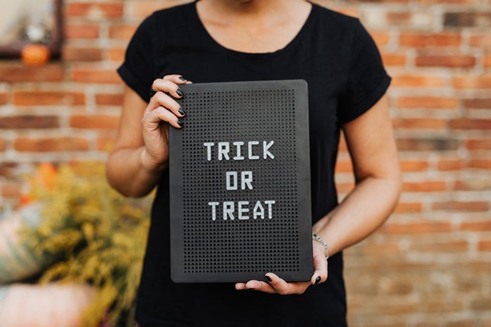 Person Holding a Trick or Treat Sign