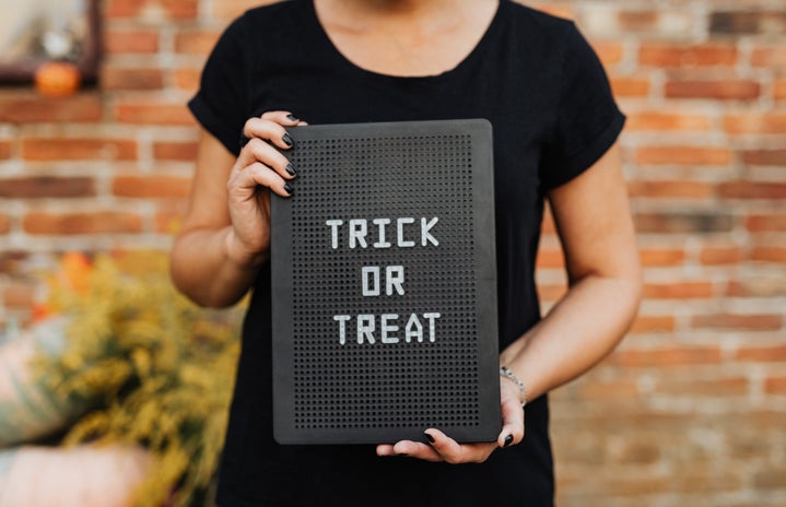 Person Holding a Trick or Treat Sign