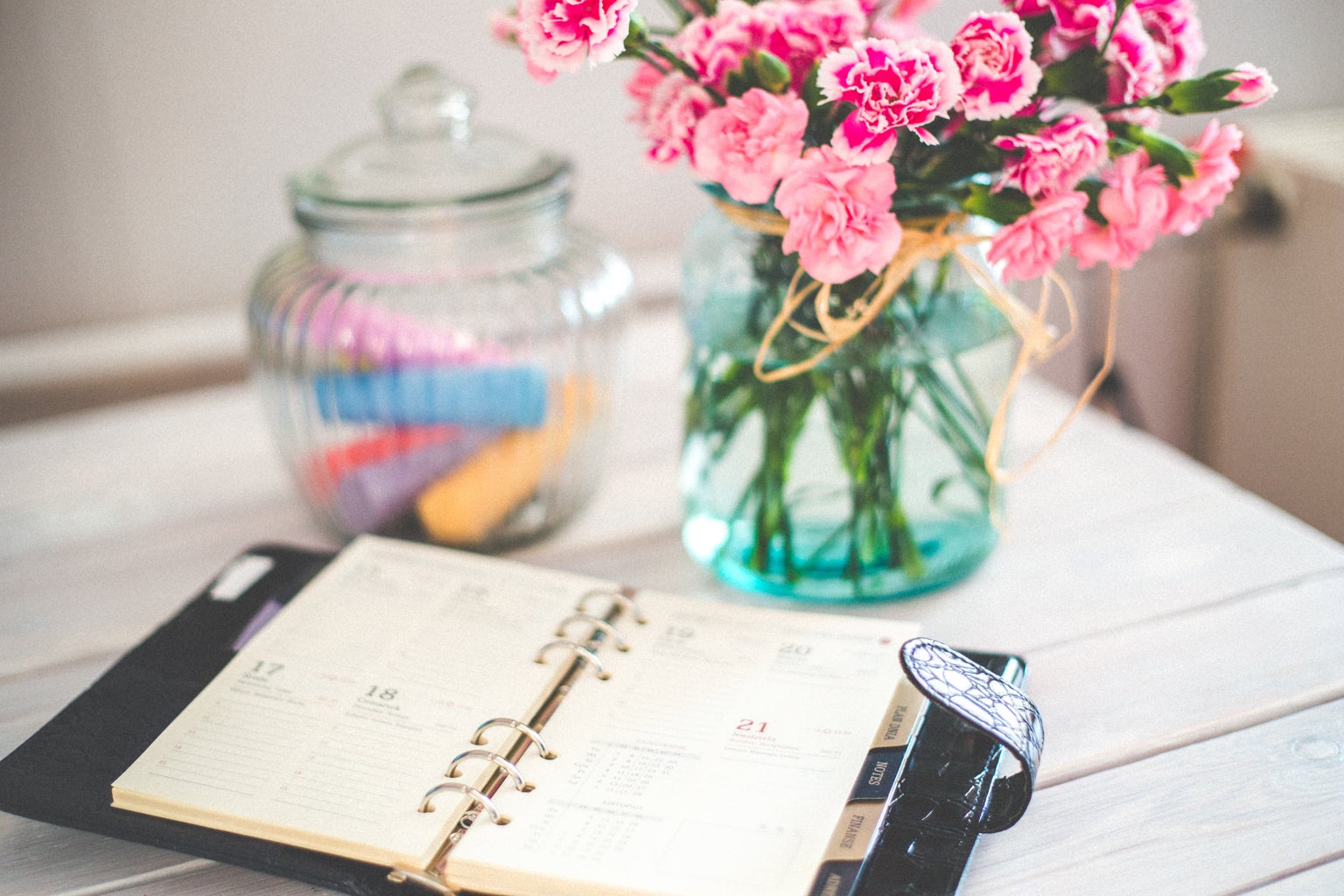 planner and pink flowers on desk