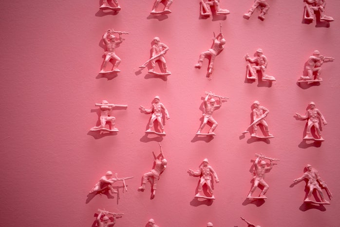 tiny pink toy soldiers on a pink wall