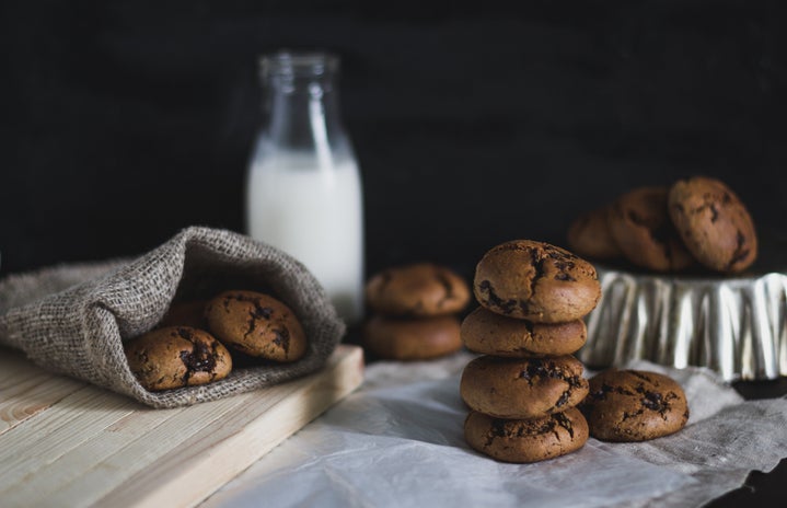 Chocolate Chocolate Chip Cookies with milk with a rustic holiday background