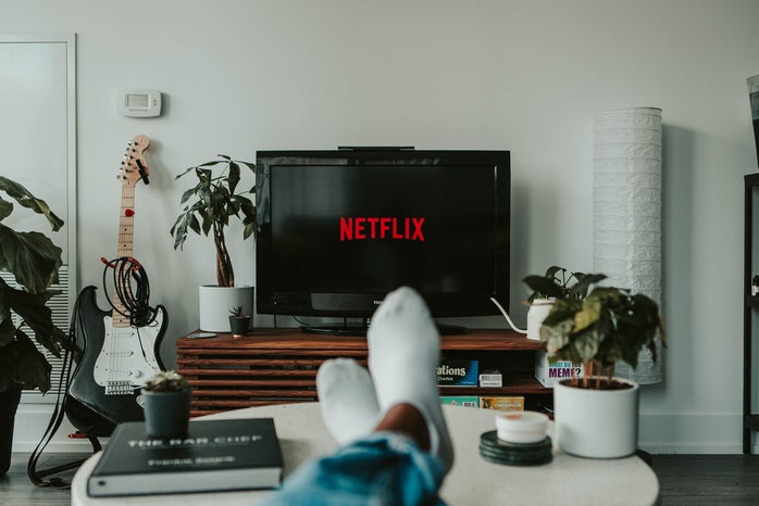 person with feet up on table watching netlfix