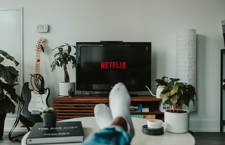 person with feet up on table watching netlfix