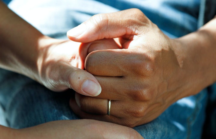A patient holding hands with their doctor